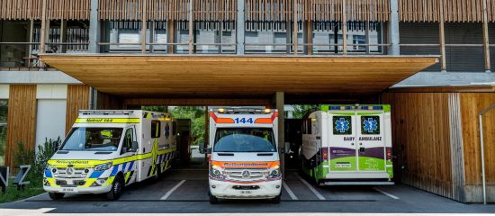Drei Ambulanzen stehen vor dem Notfall eines Spitals.